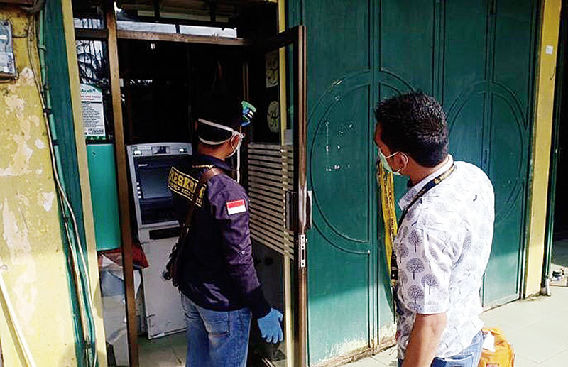 periksa atm: Dua personel polisi memeriksa ATM Bank Aceh KCP Kecamatan Baktiya Barat, Aceh Utara yang telah dipasang garis polisi untuk kepentingan penyelidikan pascapercobaan pembobolan, Kamis (12/12/2019). (RAKYAT ACEH/ RPG)