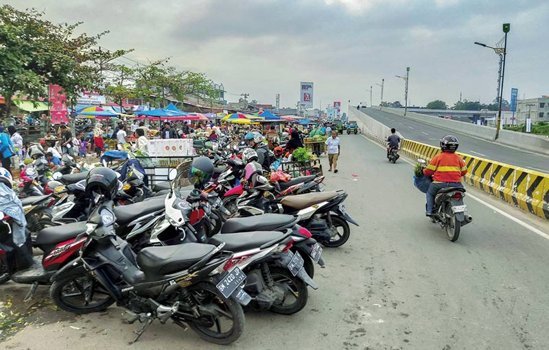 Ganggu Jalan: Sejumlah kendaraan roda dua parkir di badan jalan jalur lambat Pasar Pagi Arengka Pekanbaru, Senin (6/1/2020).  Kondisi ini mengganggu arus lalu lintas. (EVAN GUNANZAR/RIAU POS)