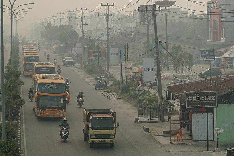 Kendaraan melintas di Jalan Hr Soebrantas di saat kabut asap tebal yang menyelimuti kota Pekanbaru,jarak pandang hingga 1,5 Km pada Senin (9/9/2019) pagi. (MHD AKHWAN/RIAUPOS)