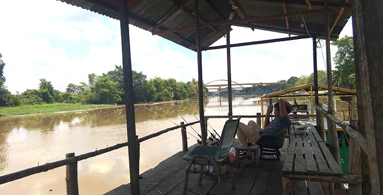 Santai Menunggu: Seorang pemancing sedang menunggu jorannya disambar ikan beberapa waktu yang lalu.