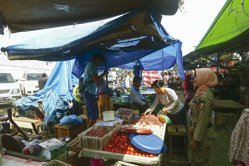 PENERTIBAN: Petugas Satpol PP Pekanbaru melakukan penertiban terhadap lapak pedagang kaki lima (PKL) di depan Pasar Pagi Arengka, Jalan Soekarno-Hatta, Selasa (5/11/2019). (EVAN GUNANZAR/RIAU POS )