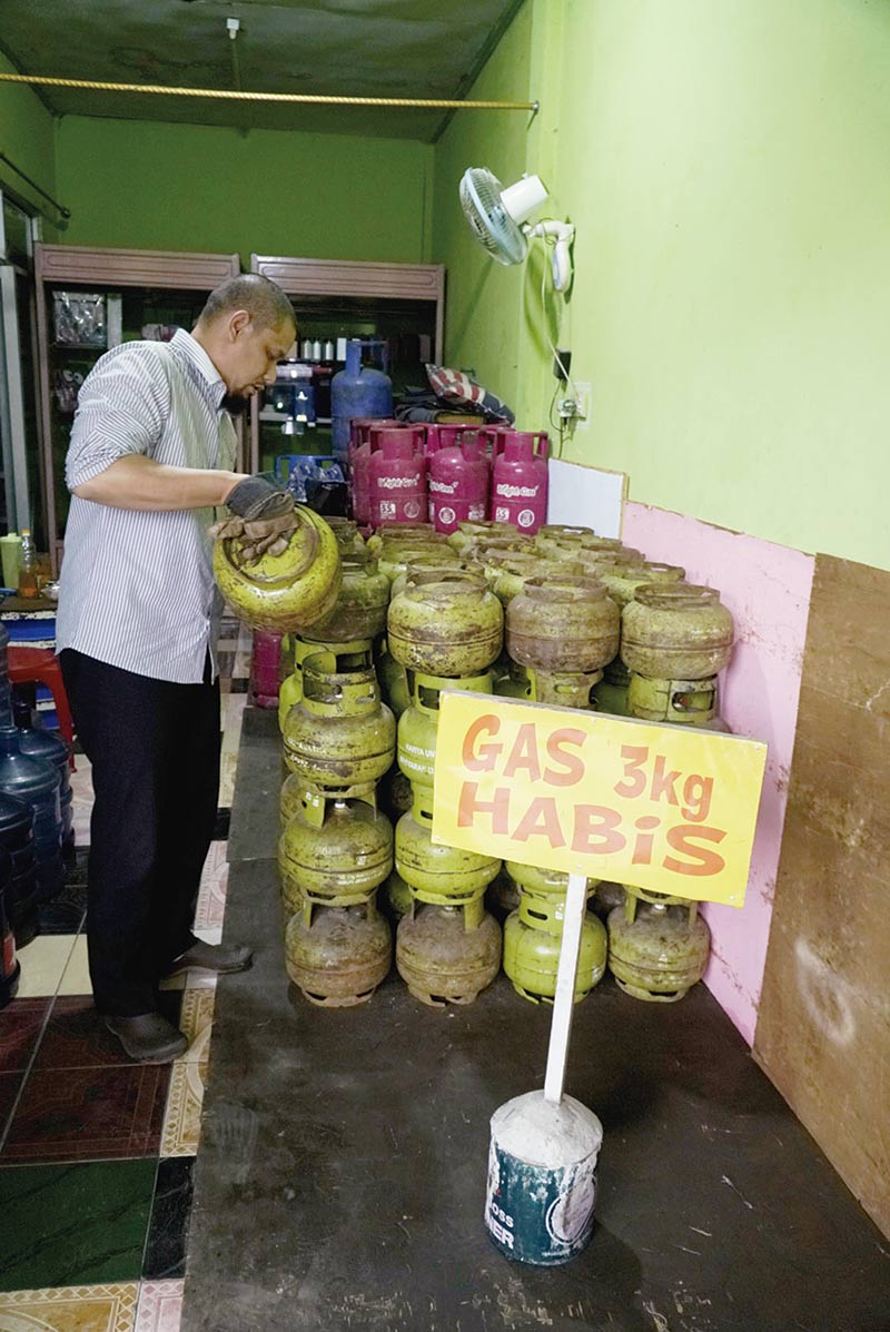 HABIS: Pemilik pangkalan gas menyusun tabung-tabung elpiji 3 kg kosong di pangkalan gas Jalan Balam ujung, Selasa (19/11/2019). (DEFIZAL / Riau Pos )